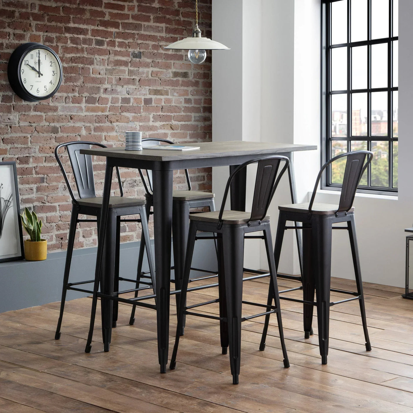 Industrial bar table and four metal bar stools with wood seats in loft dining area