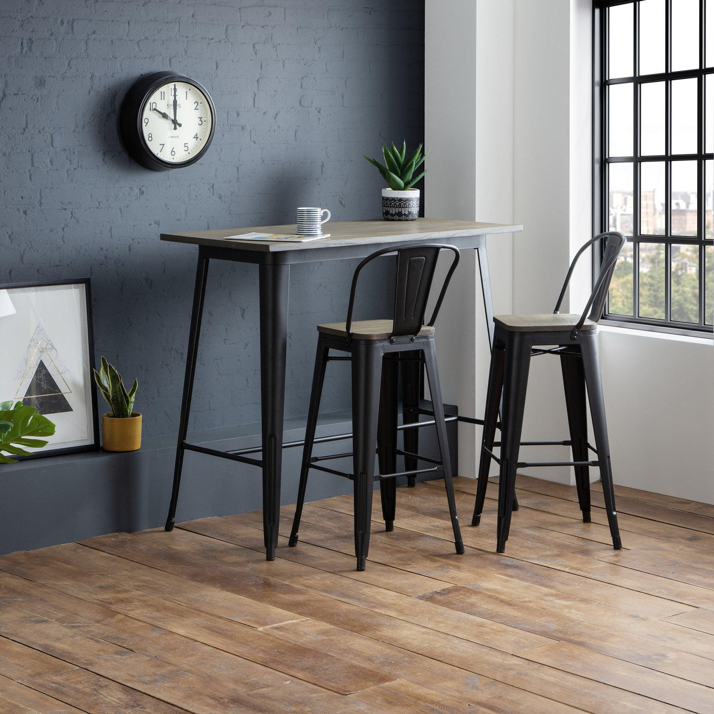 Industrial style bar table with two black and wood bar stools in modern room