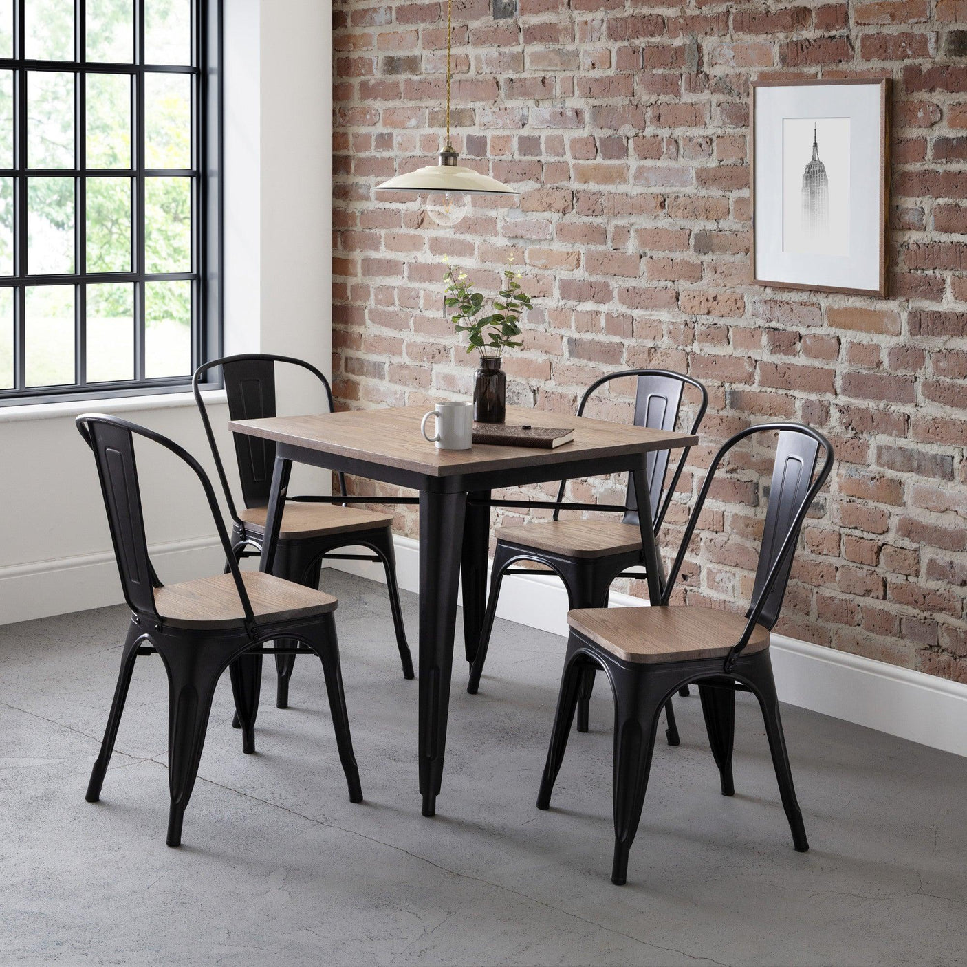 Industrial dining table set with four black chairs and wood seats in modern kitchen