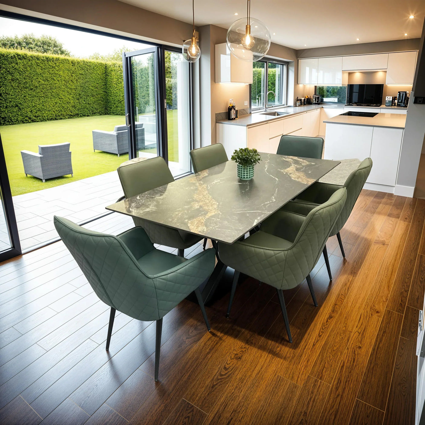 Rectangular marble dining table with six green upholstered chairs in modern kitchen