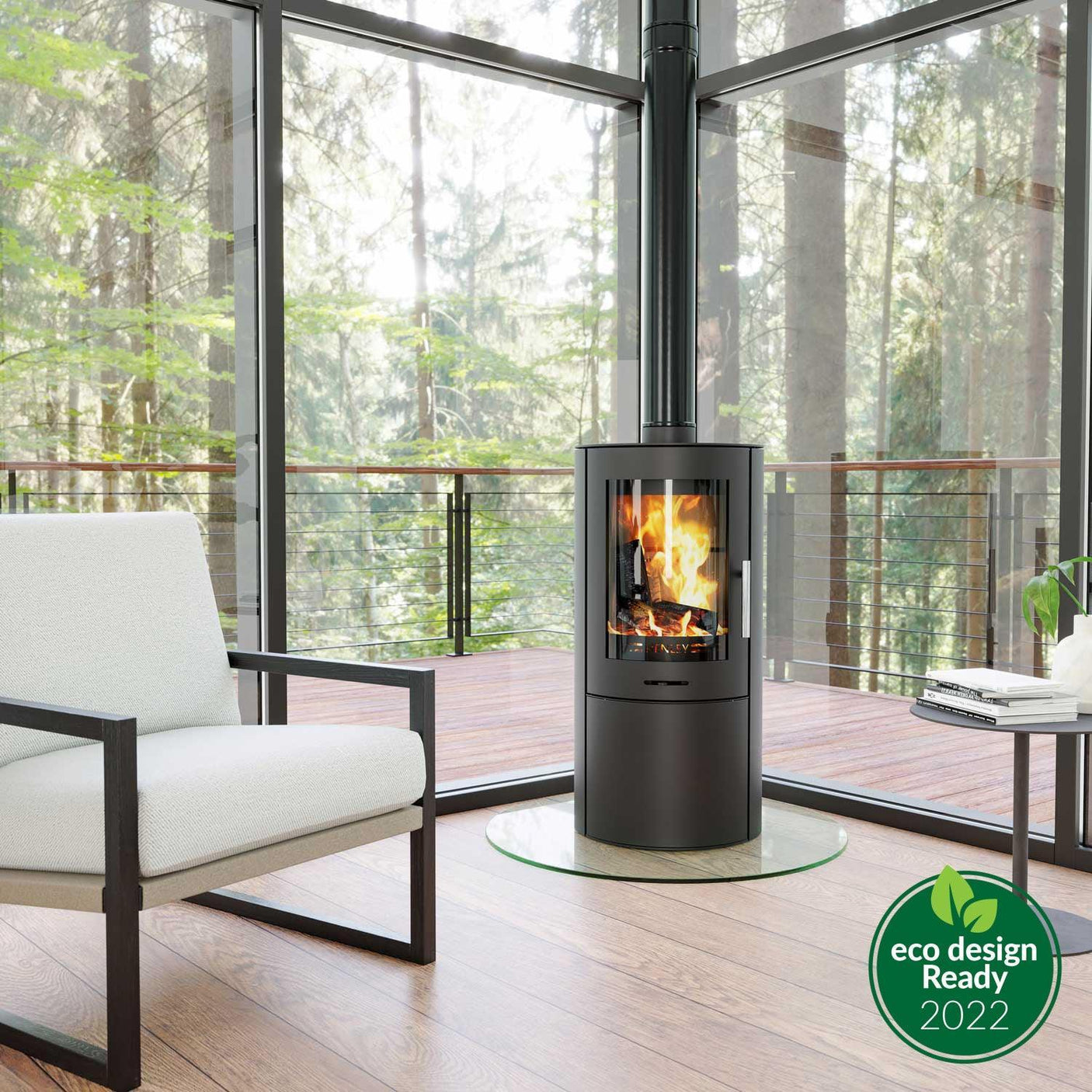 Modern wood burning stove with glass door in bright living room, white armchair nearby