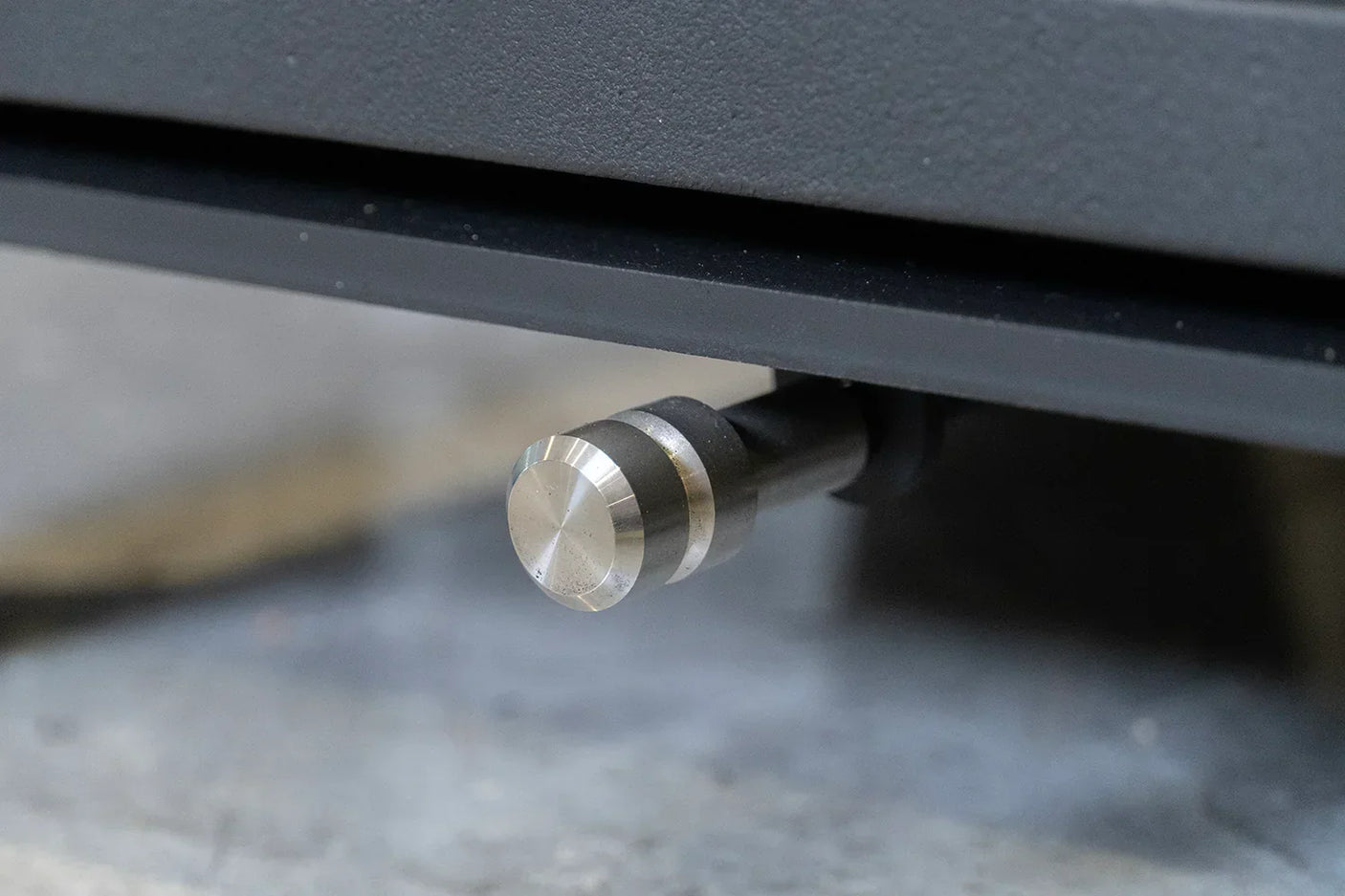 Close up of brushed metal bottom handle on black furniture piece