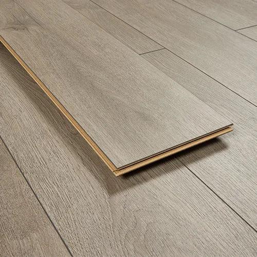 Greige oak laminate flooring plank with wood grain texture on installed floor