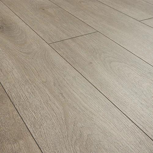 Greige oak laminate flooring with wood grain texture and matte finish, angled view