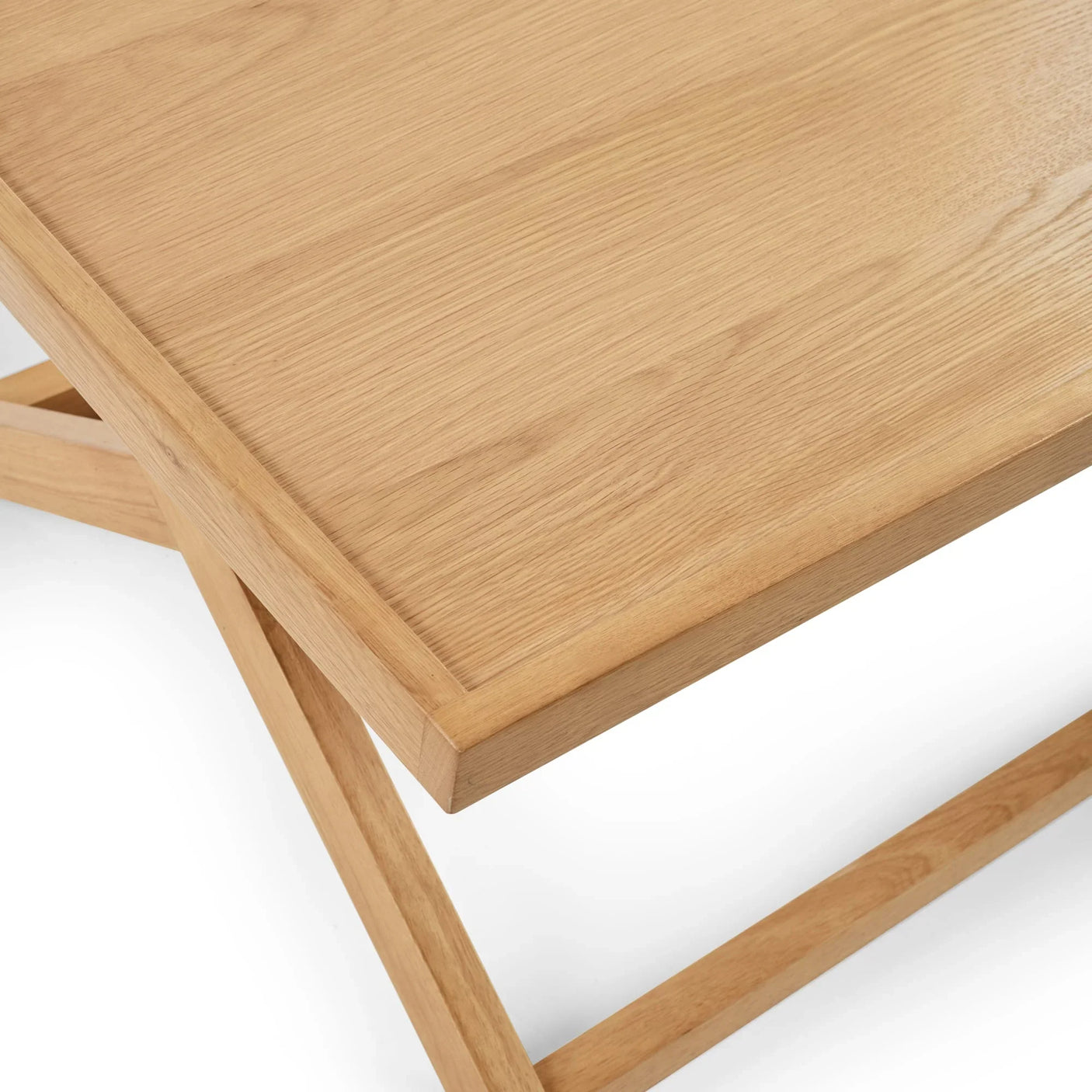 Corner view of natural oak coffee table with smooth wood grain and modern leg design