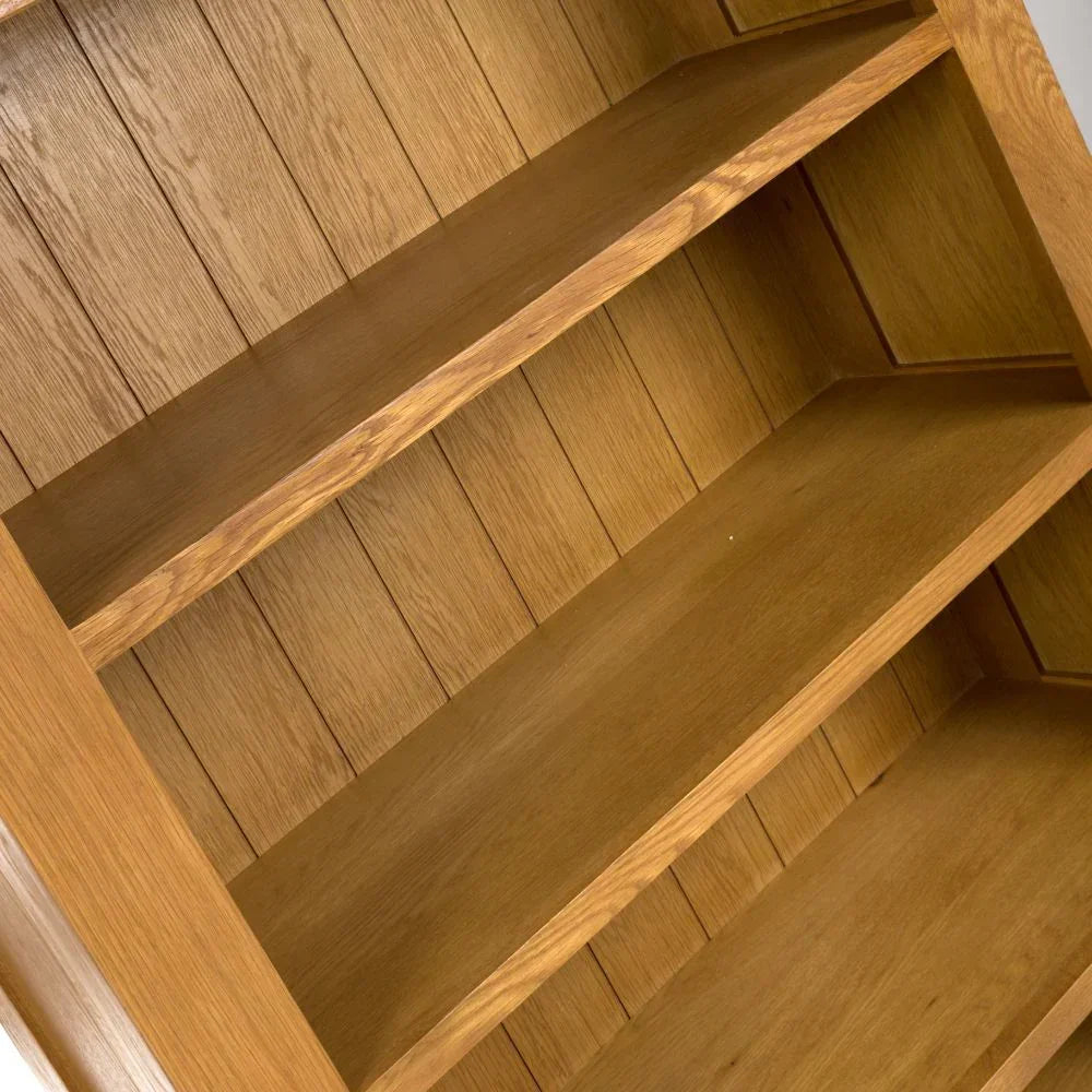 Closeup angled view of empty oak bookcase shelves with wood grain finish
