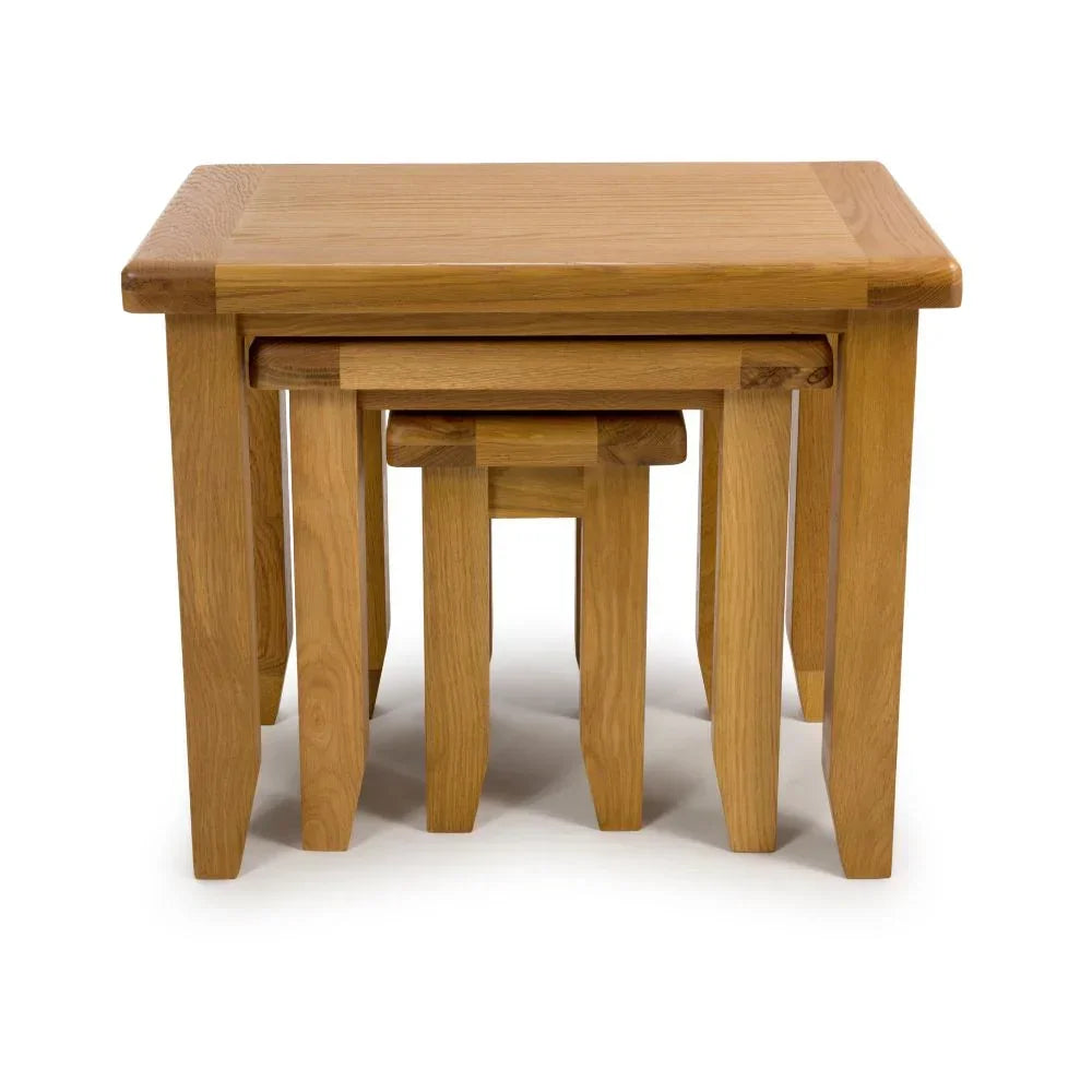 Set of three oak nesting tables with natural wood finish, stacked neatly together