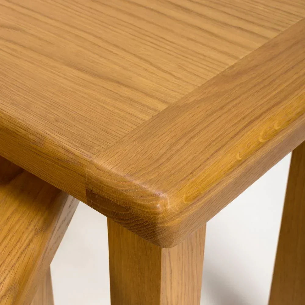 Closeup of oak nest of tables with smooth edge and natural wood grain finish