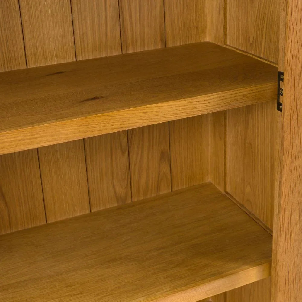 Close up of oak bookcase shelves showing wood grain and vertical panelled back