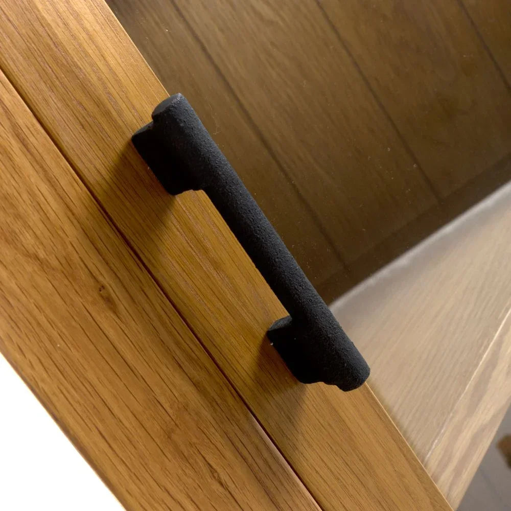 Oak cabinet door with black metal handle close-up