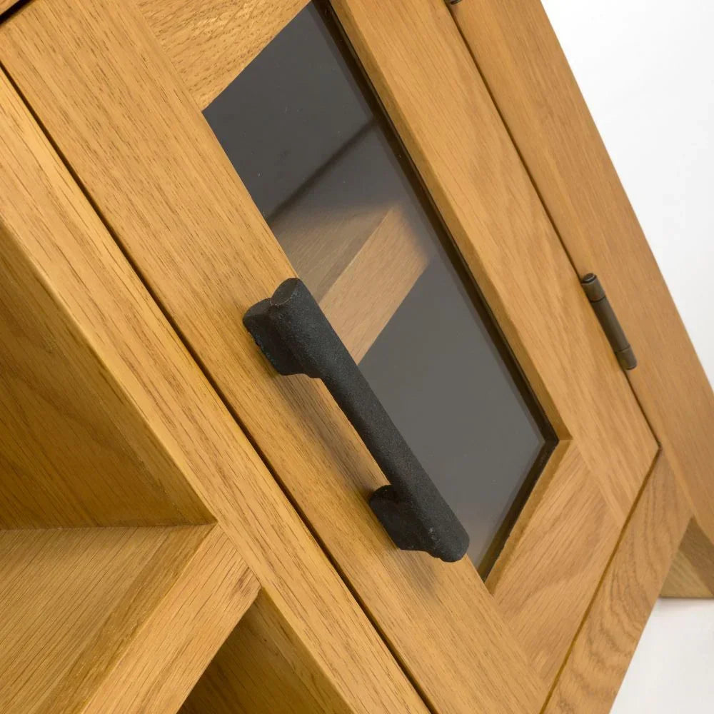 Close up of oak cabinet door with black metal handle and clear glass panel