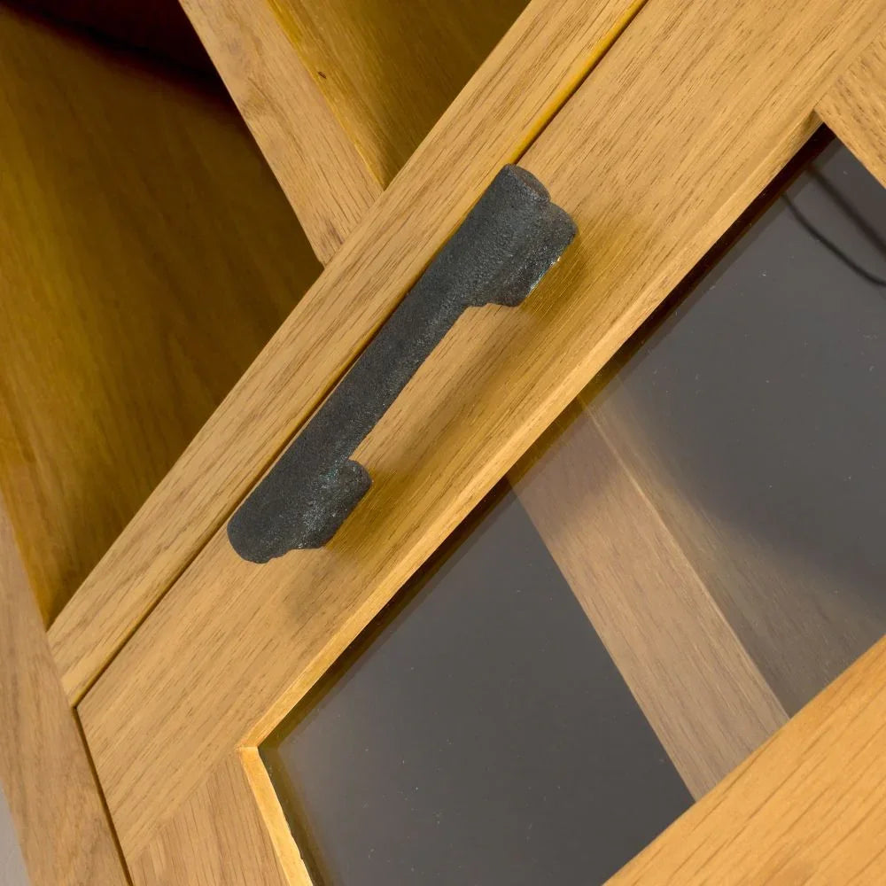 Oak cabinet door with glass panel and black metal handle in close-up view
