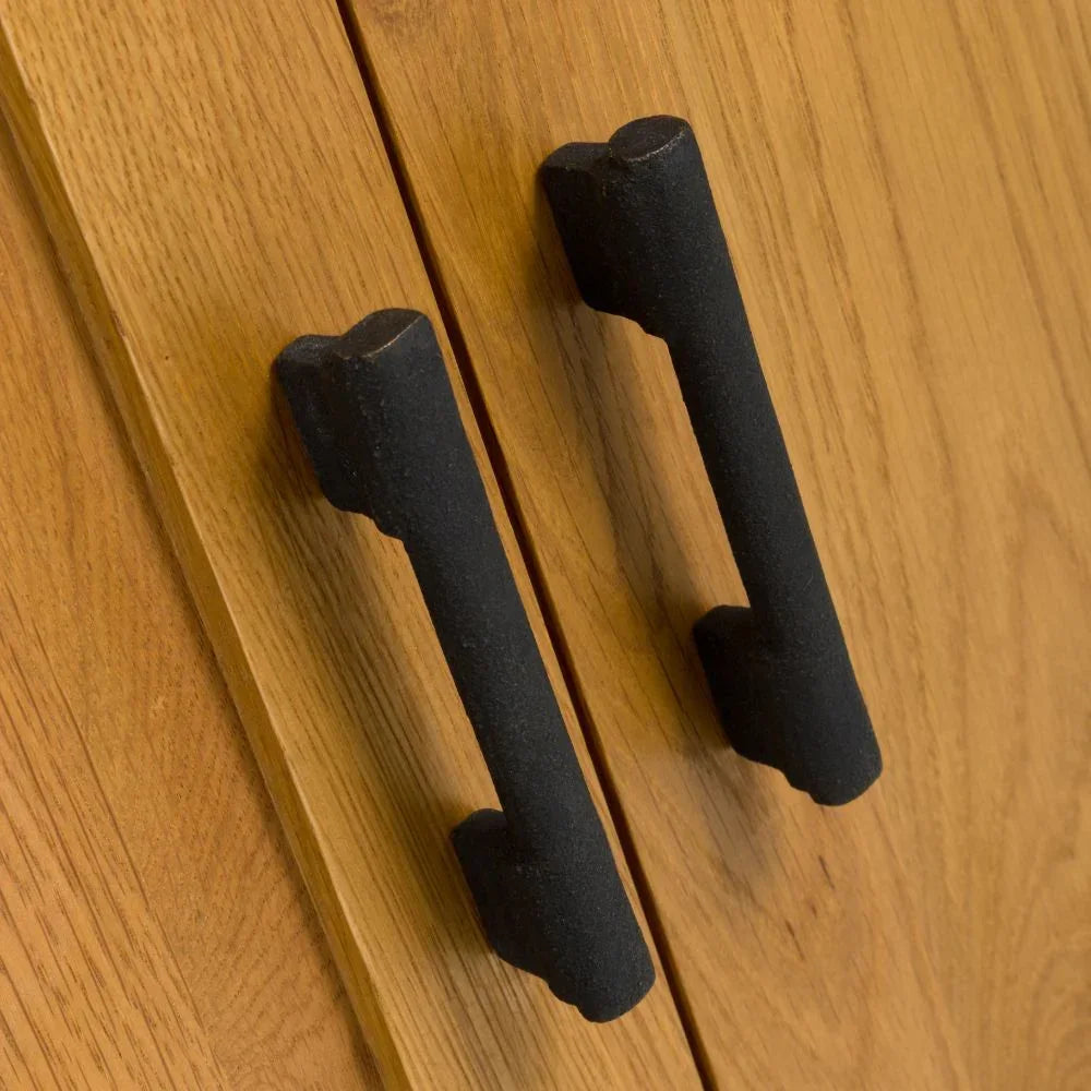 Closeup of black metal cabinet handles on oak wood cupboard doors