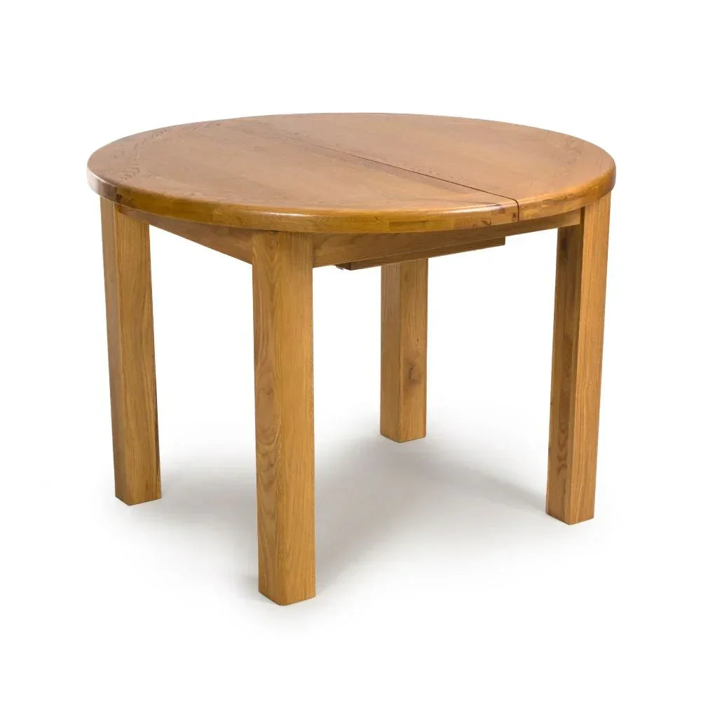 Round oak dining table with four sturdy legs and visible wood grain