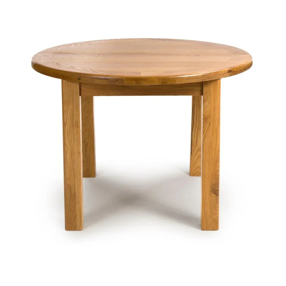 Round oak dining table with four sturdy legs on white background