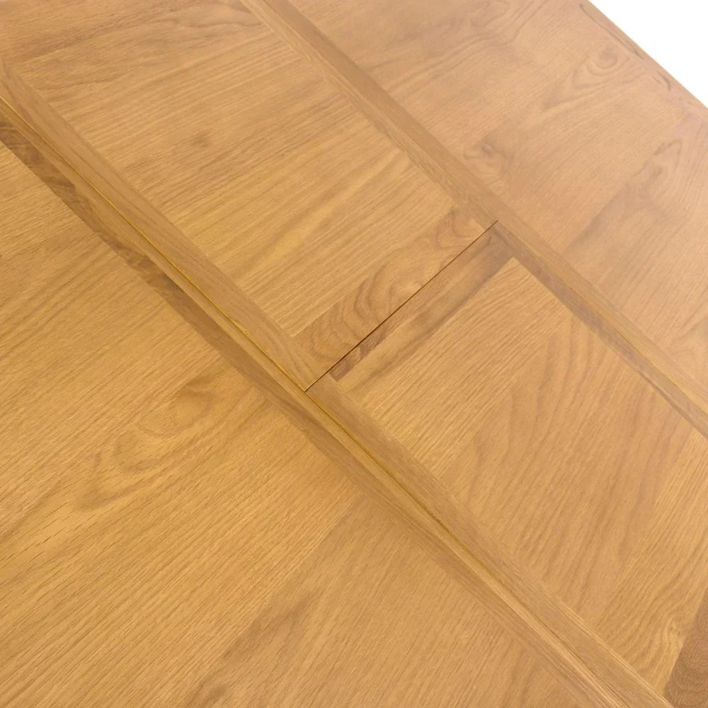 Oak wood dining table with visible extension leaf and natural grain finish