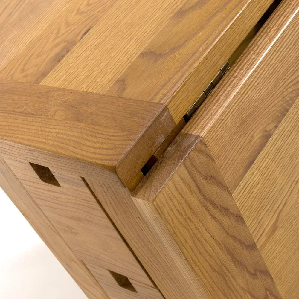 Close up of solid oak dining table corner with visible hinge and wood grain detail
