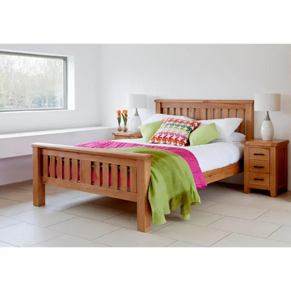 Solid oak bed frame with matching bedside tables and colorful bedding in a modern bedroom