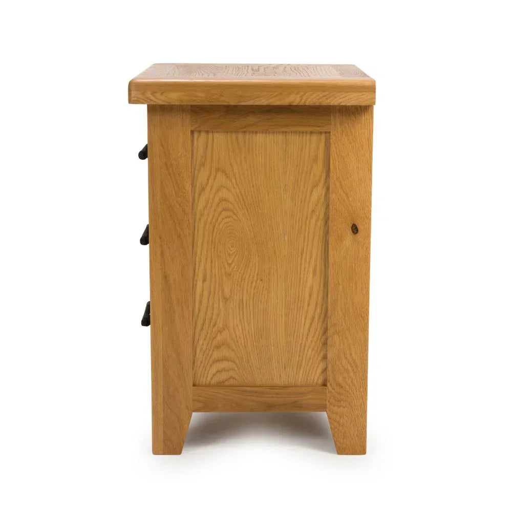 Side view of oak chest of drawers with panel detail and natural wood grain