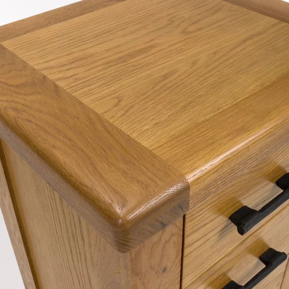 Oak chest of drawers corner detail with metal handles and smooth wood grain finish