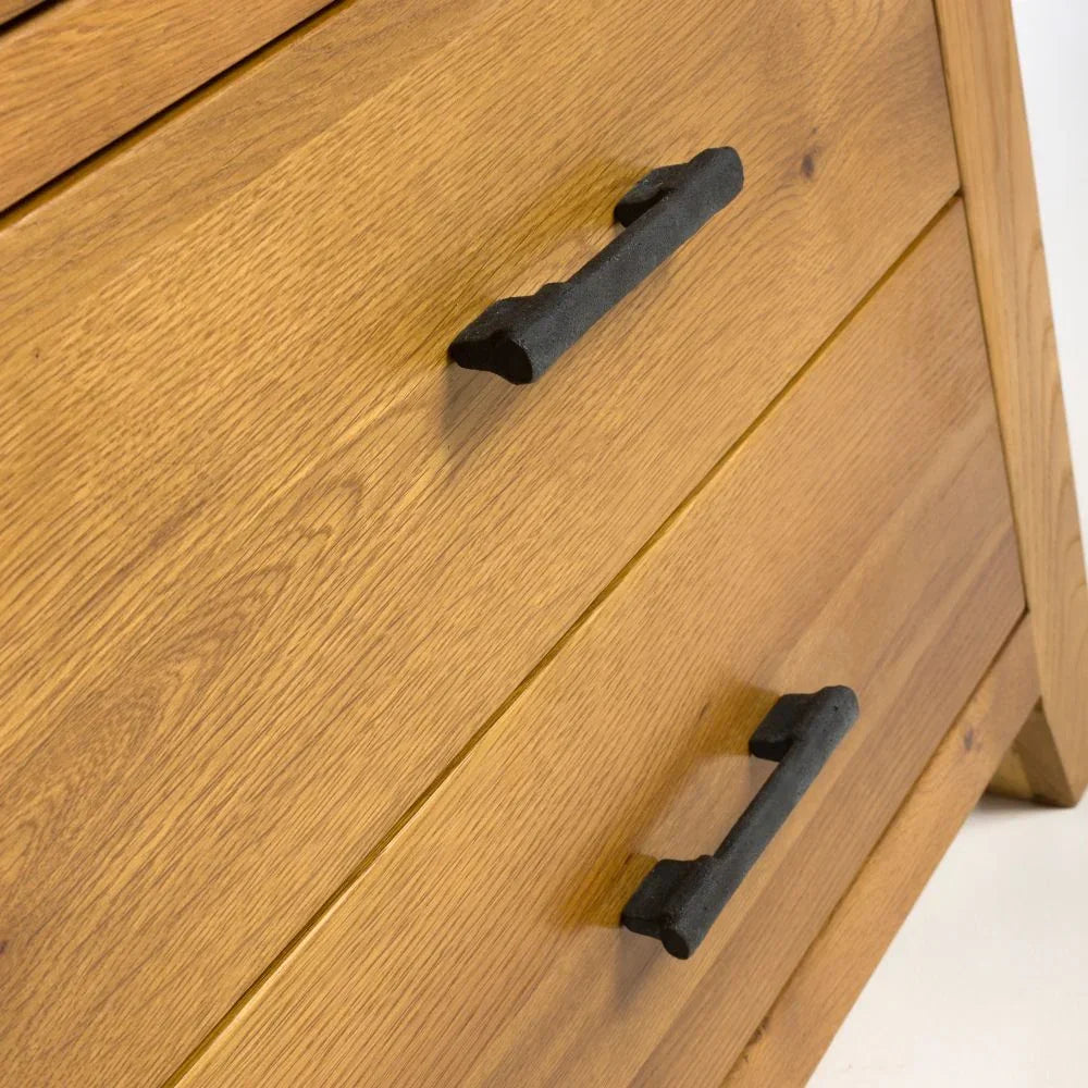 Oak wood chest of drawers with black metal handles close-up