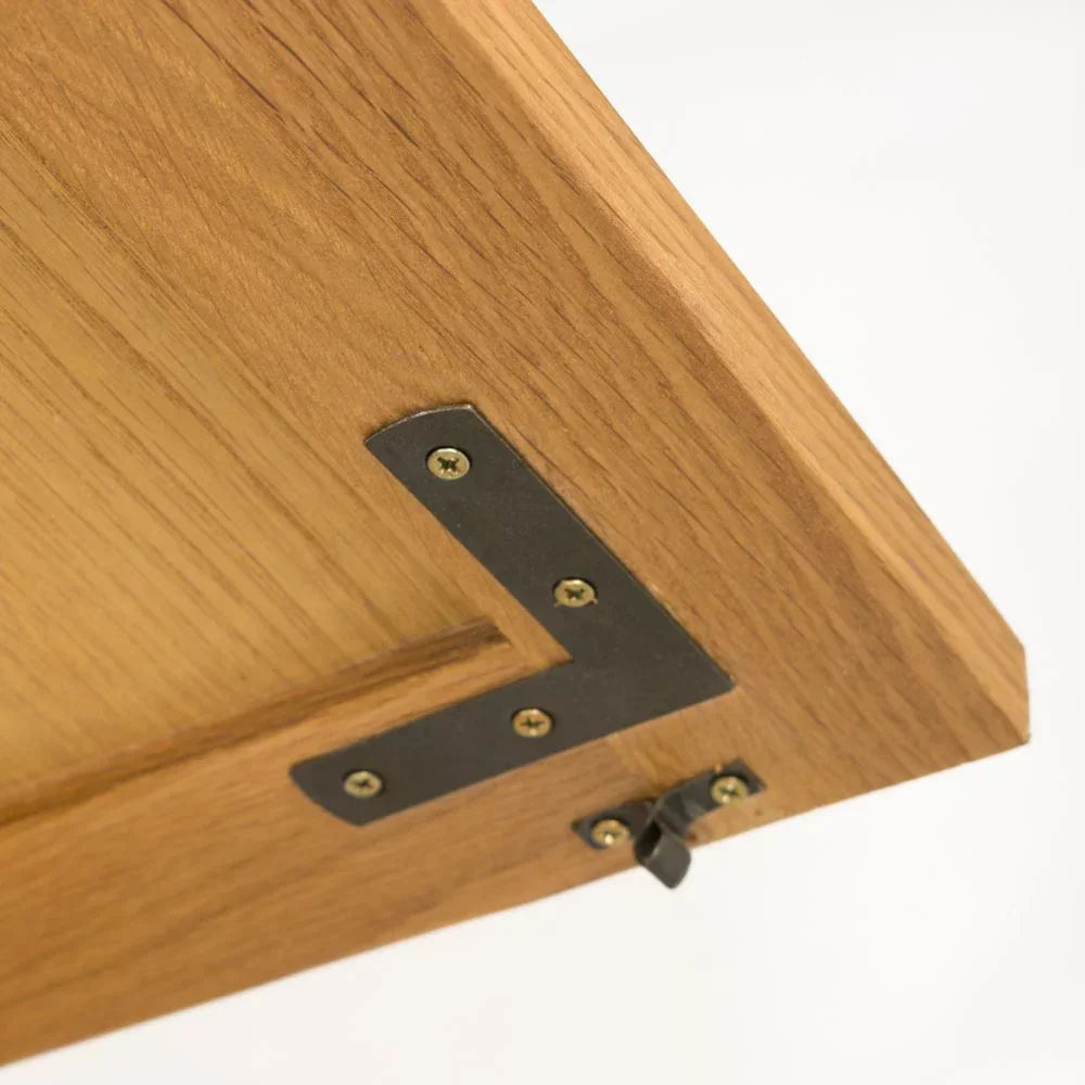 Oak furniture corner detail with black metal bracket and visible hinge hardware