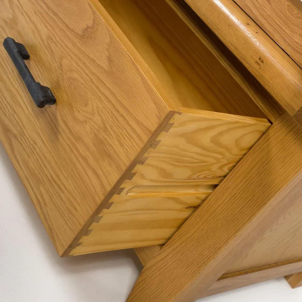 Oak drawer unit with dovetail joints and black handle, close-up of craftsmanship detail