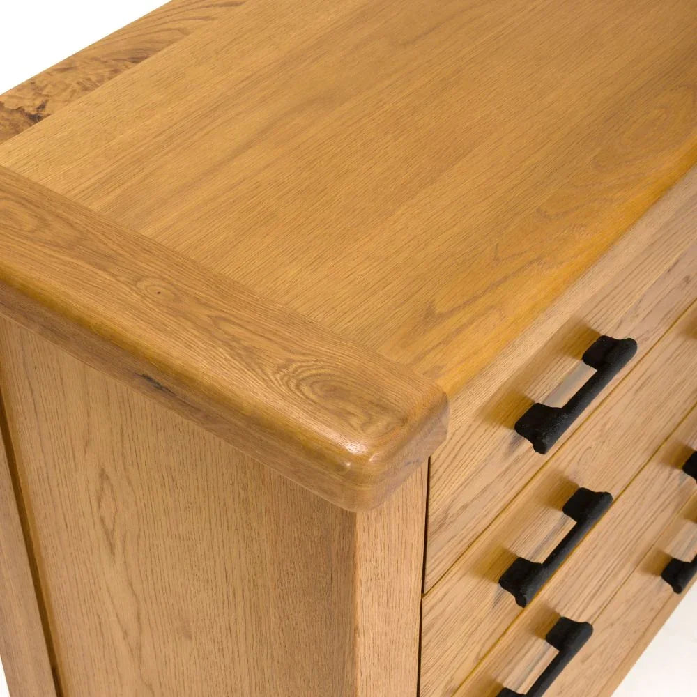 Oak chest of drawers with black metal handles, close up of corner and drawer fronts
