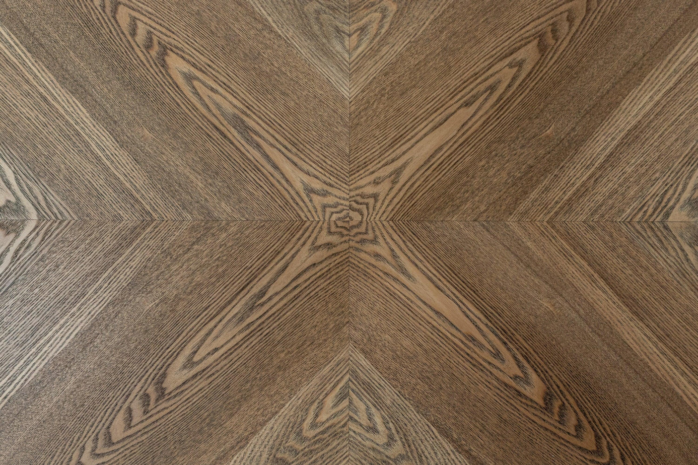 Closeup of oak veneer table top with chevron wood grain pattern