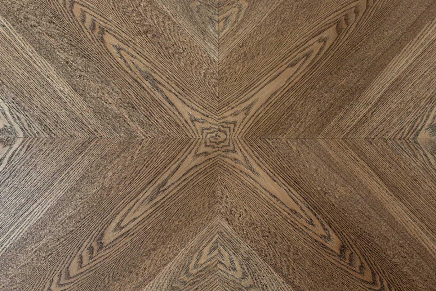 Closeup of wood dining table surface with chevron patterned oak veneer
