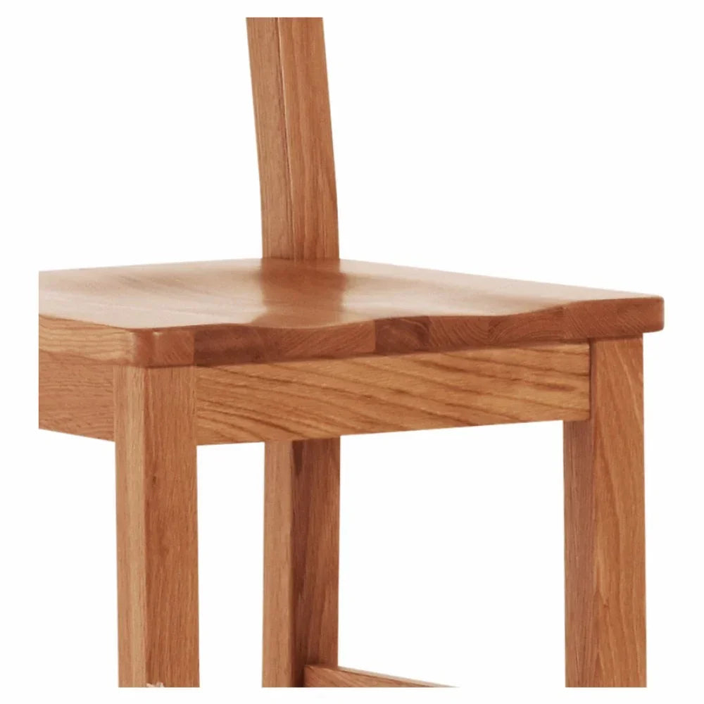 Close-up of solid wood dining chair with natural finish and square leg detail