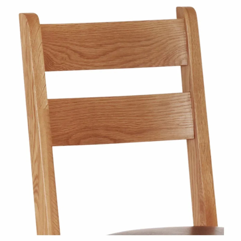 Closeup of wooden dining chair backrest with horizontal slats and light oak finish