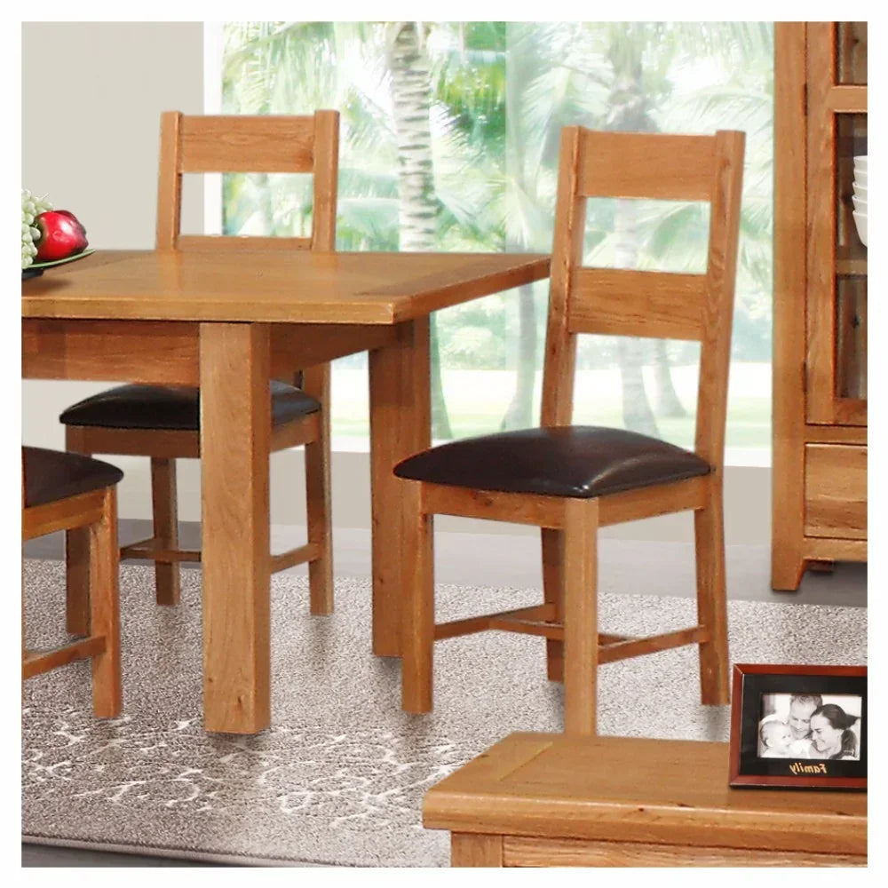 oak dining table set with brown leather chairs on patterned rug in bright room