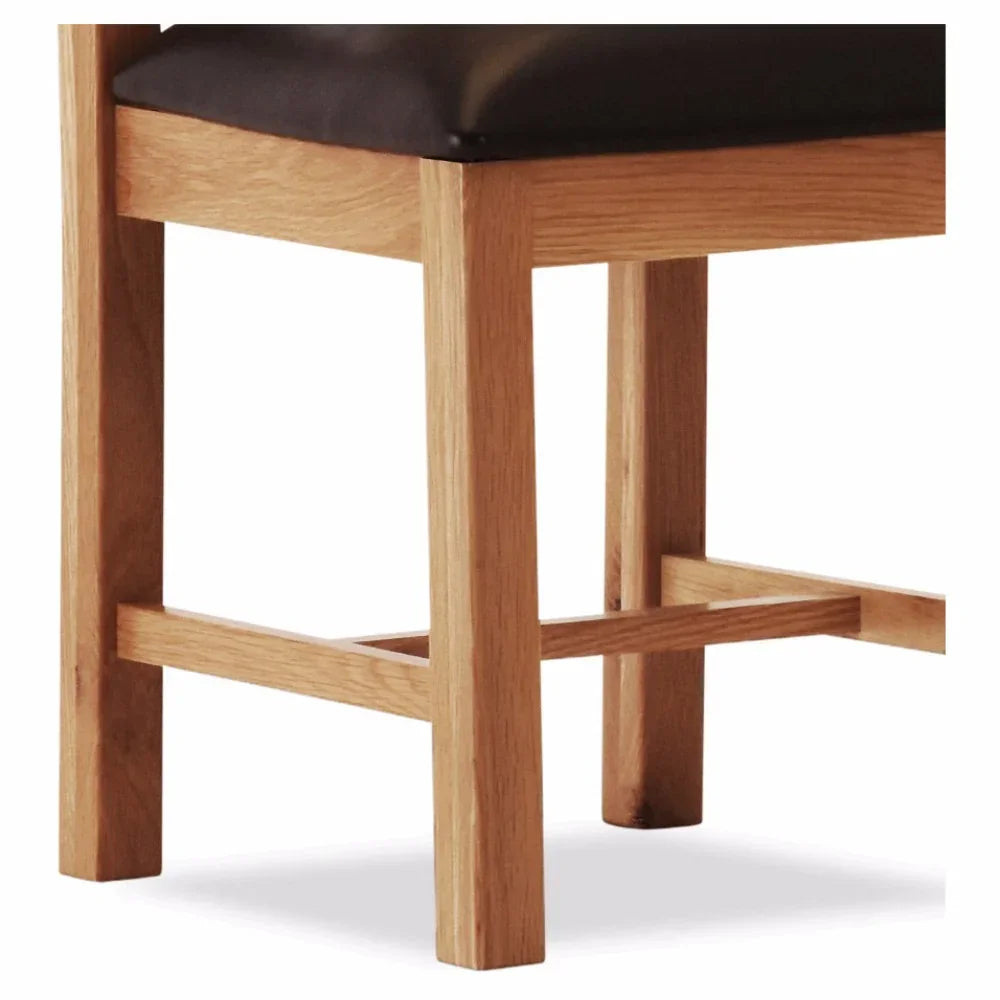 Light oak dining chair legs with black seat cushion close-up