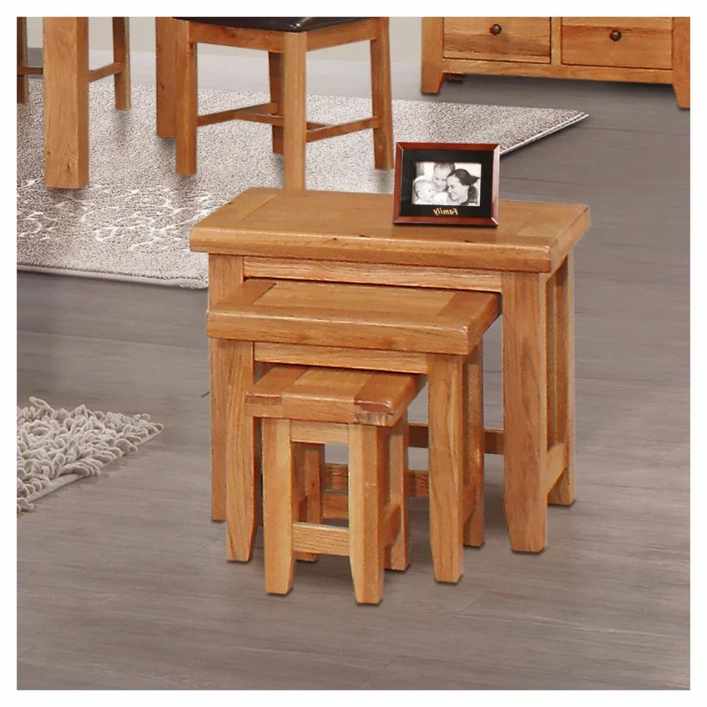 Oak nesting tables set of three with photo frame on top, displayed in living room