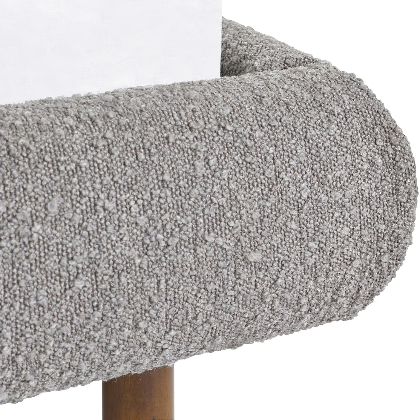 Close-up of grey upholstered bed frame corner with textured fabric and wooden leg