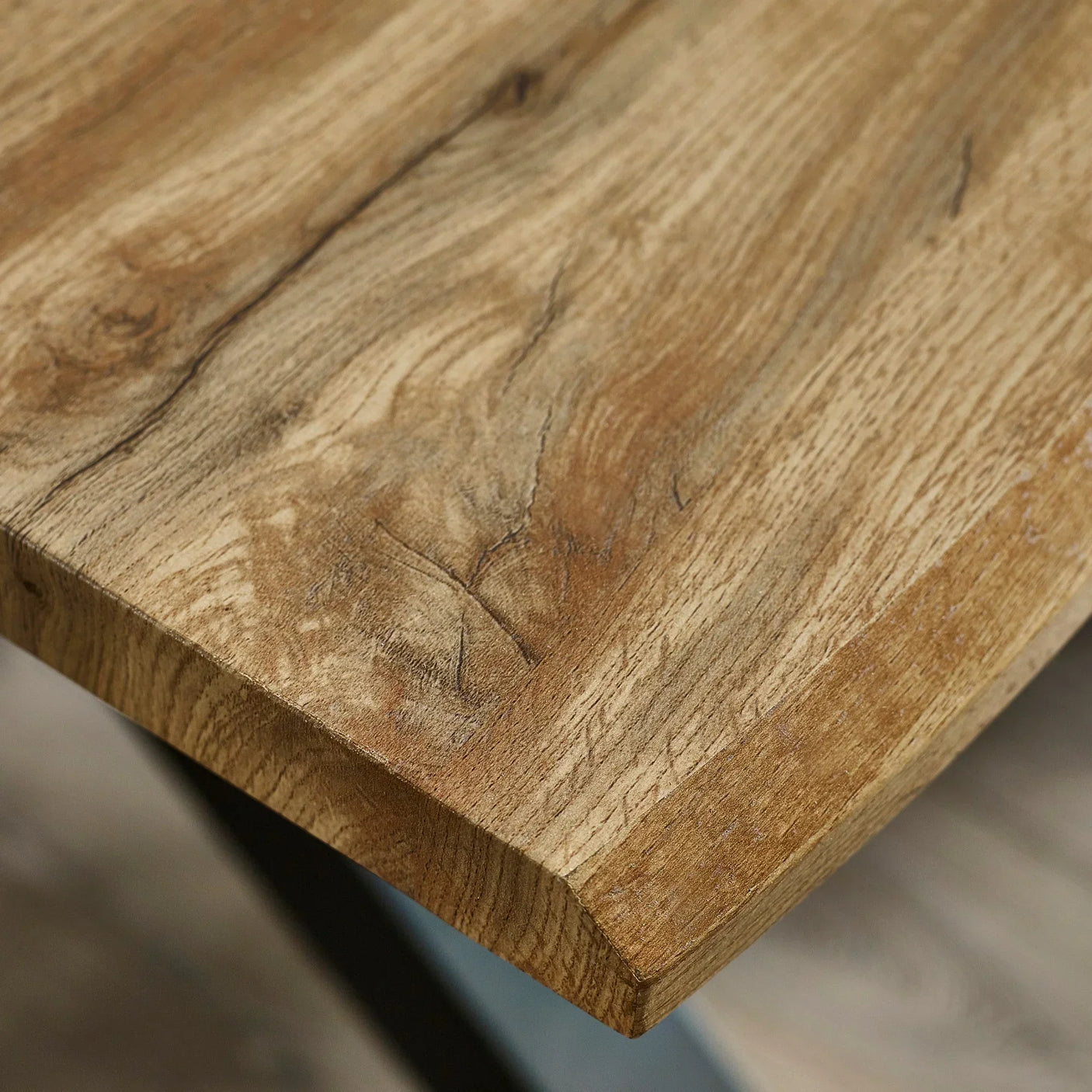 Closeup of solid wood dining table corner with natural grain and rustic finish