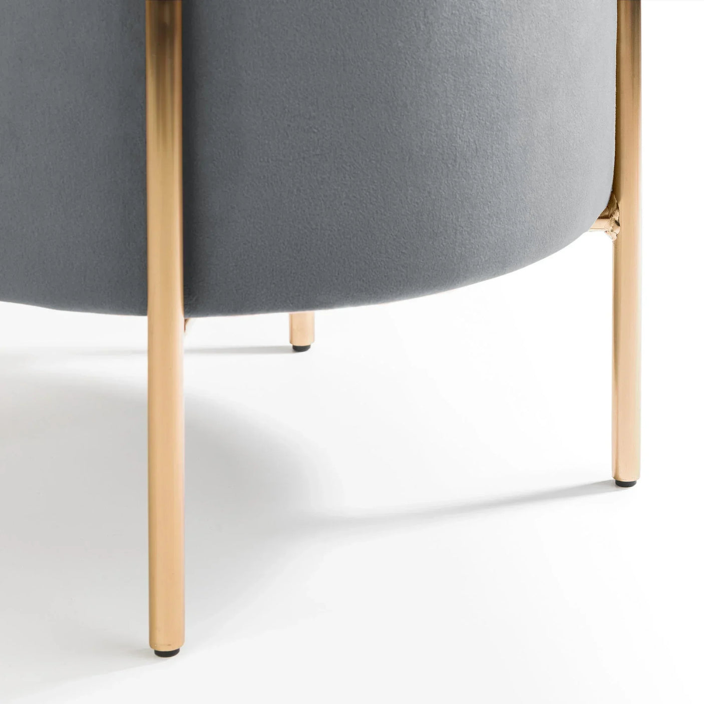 Grey stool upholstery with gold metal legs closeup