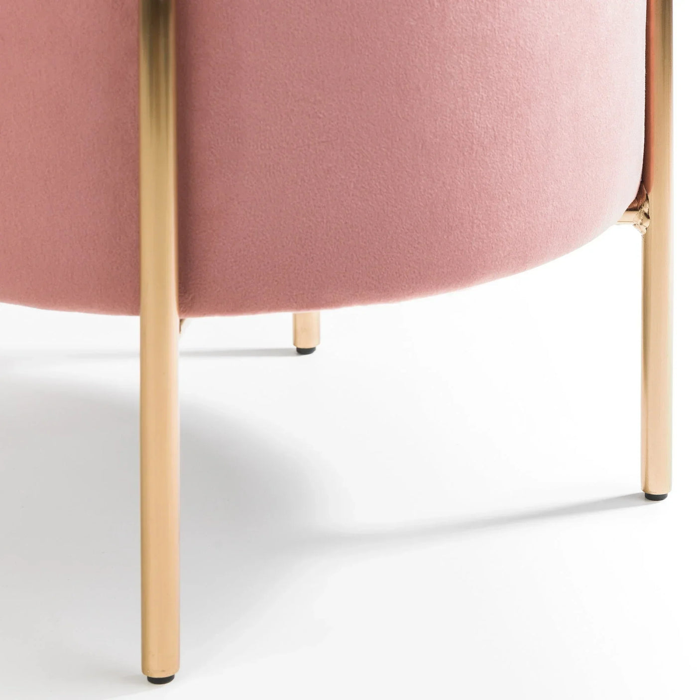 Close-up of pink stool upholstery with gold metal legs on white background
