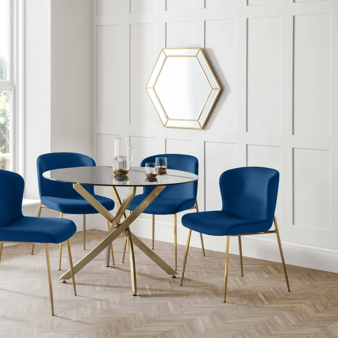Blue dining chairs with gold legs around round glass table in modern dining room