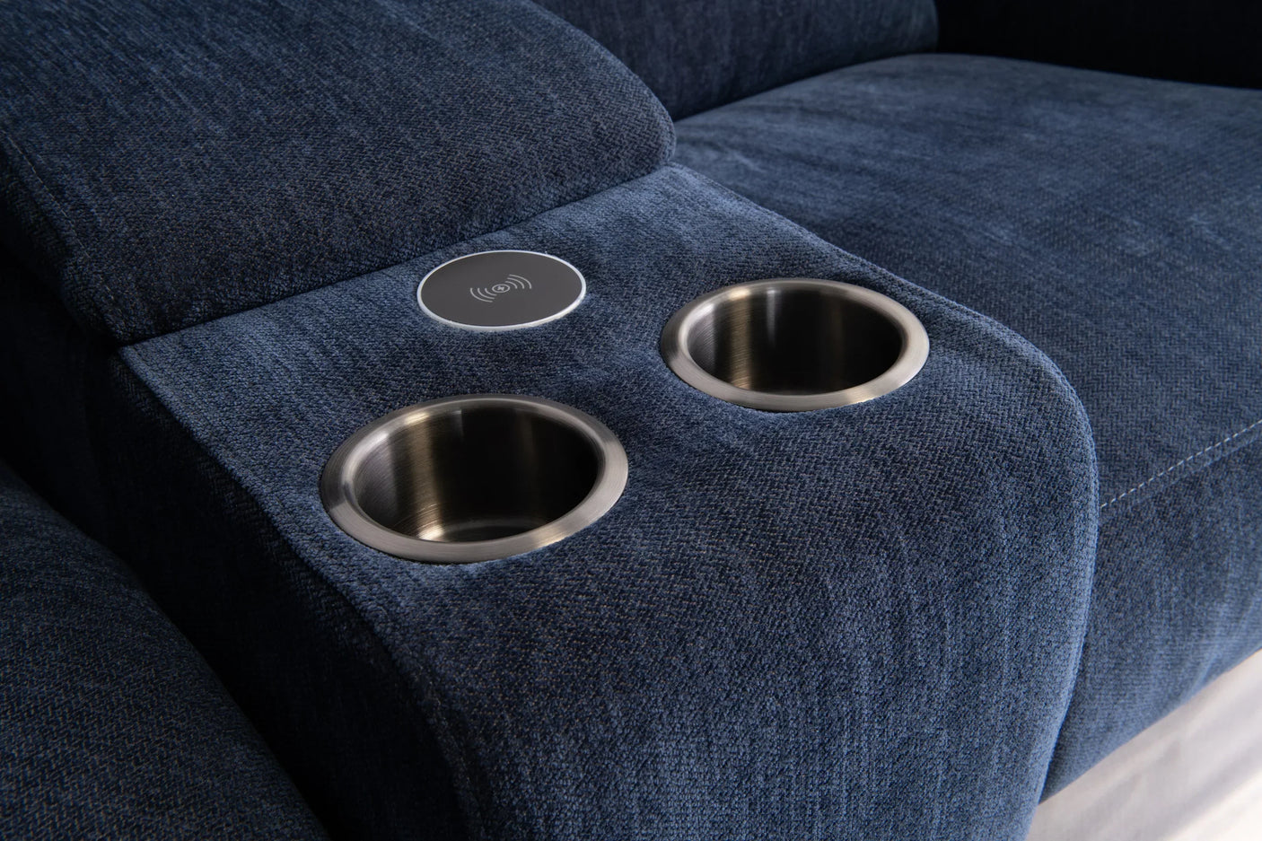 Blue fabric sofa console with two stainless steel cup holders and wireless charging pad