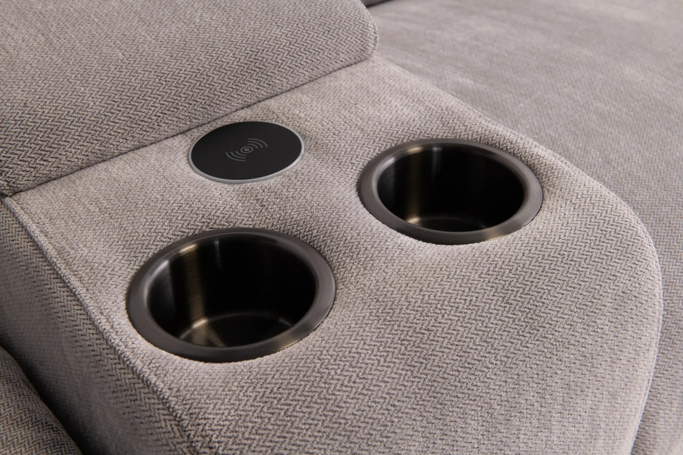 Grey fabric sofa console with two metal cup holders and wireless charging pad