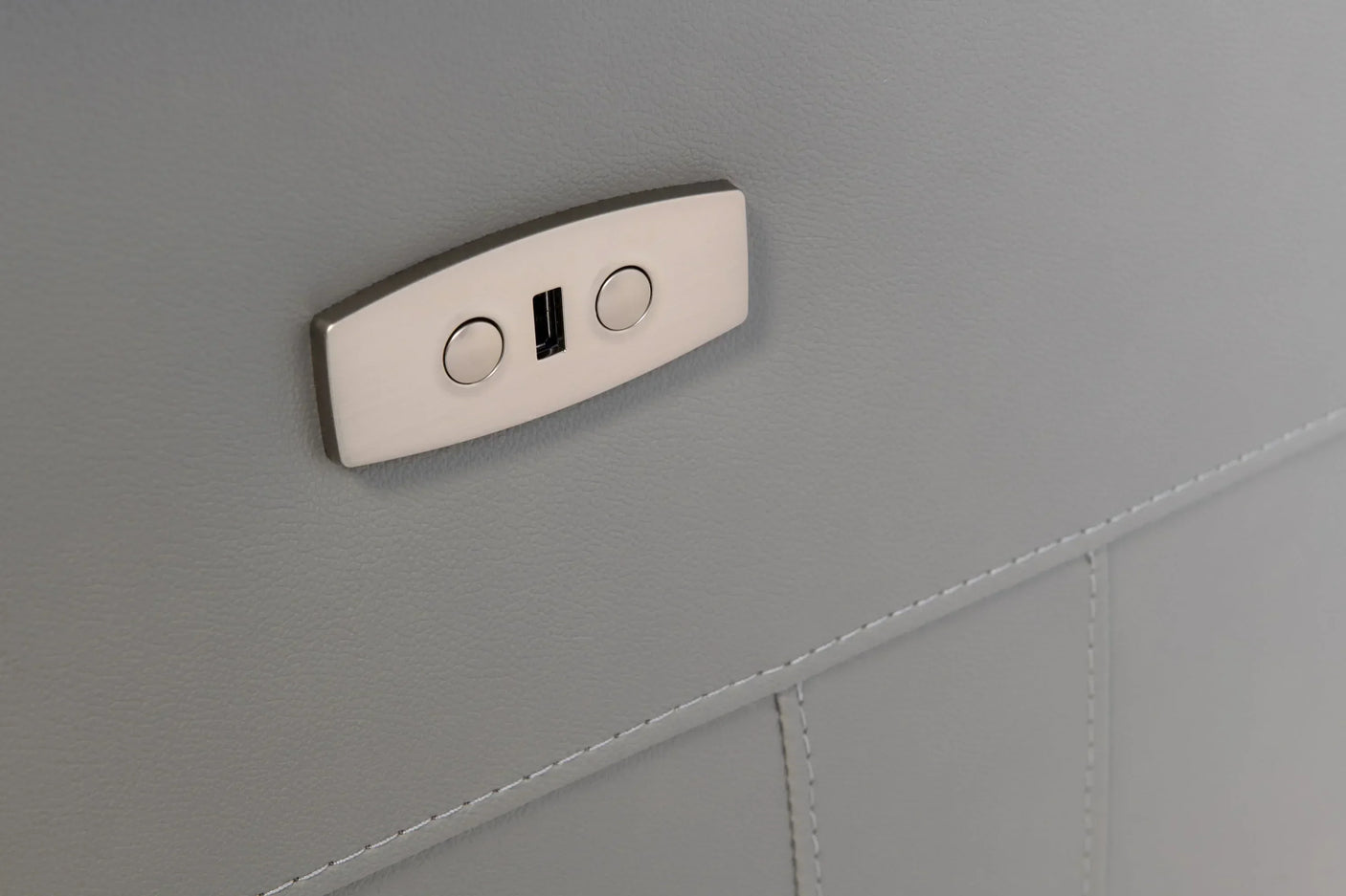 Grey leather sofa control panel with USB port and stitching detail