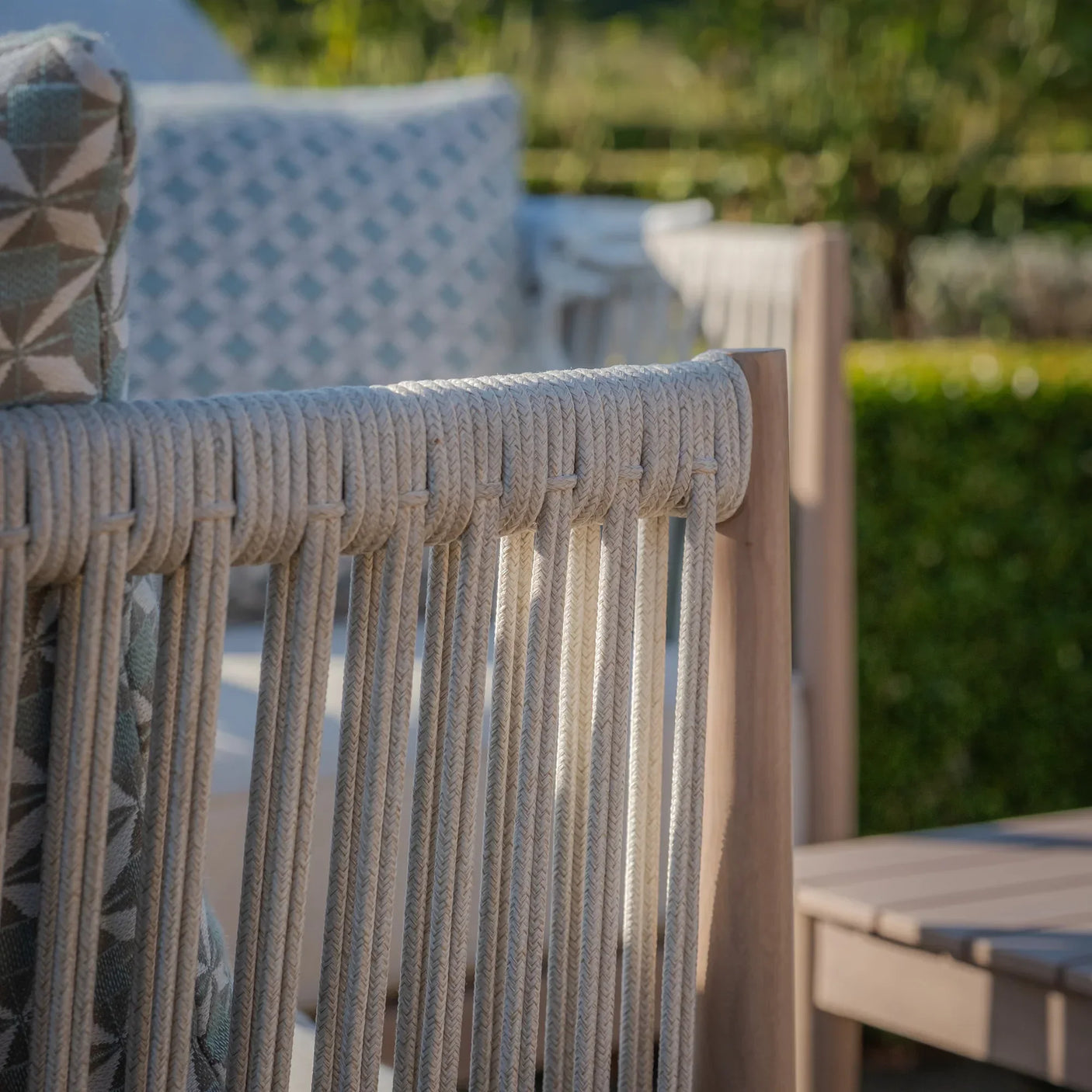 Close-up of outdoor rope garden furniture armrest with patterned cushions