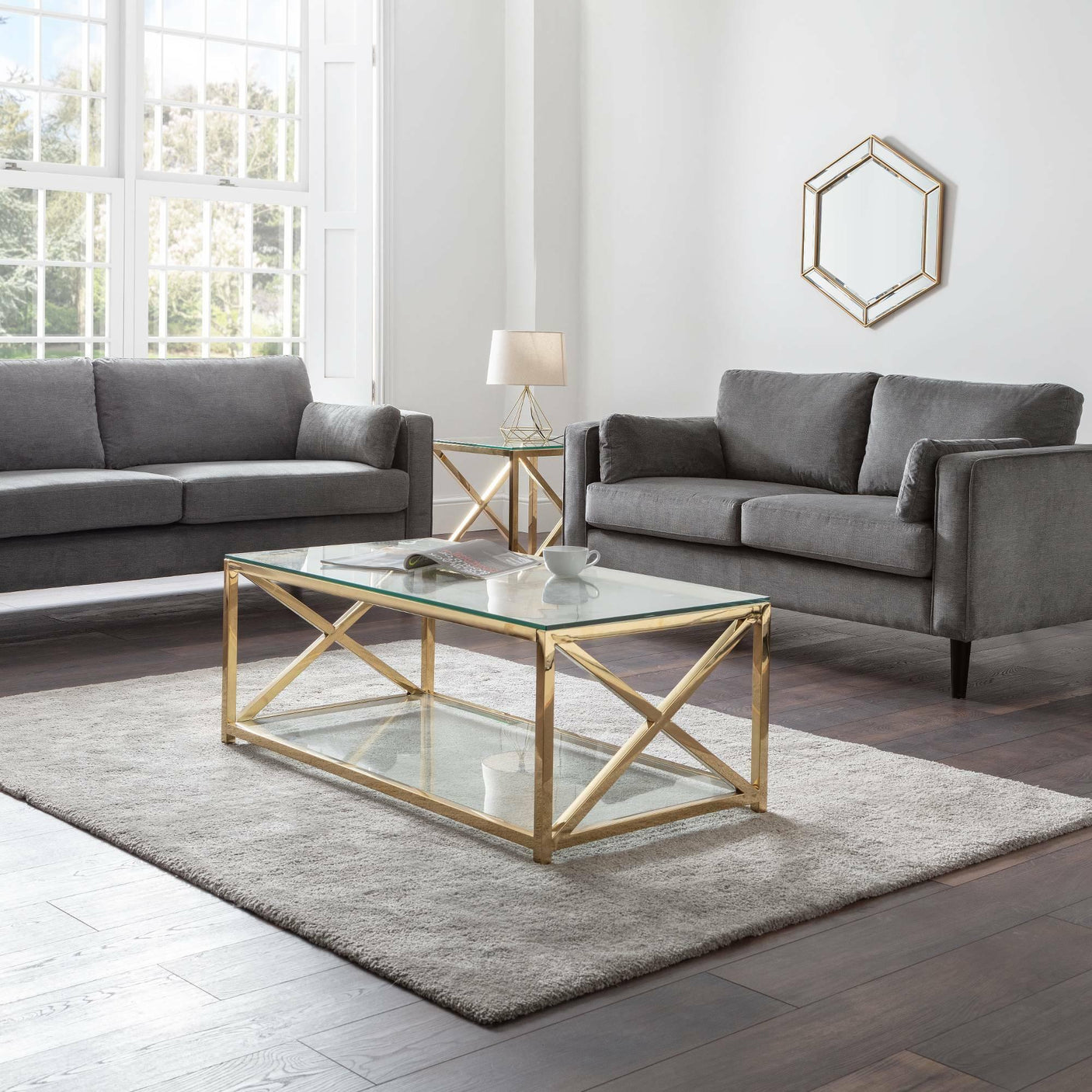Dark grey chenille 2 seater and 3 seater sofas with gold glass coffee table in bright living room