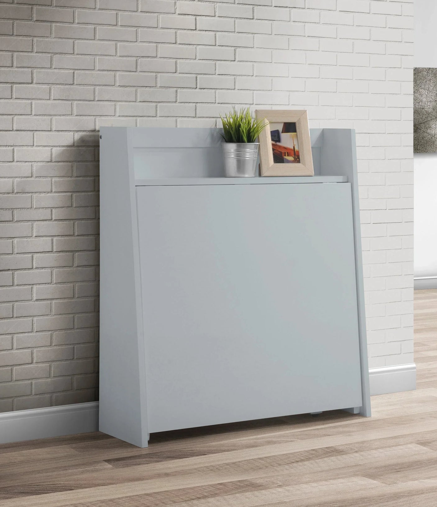 Compact folding light grey dining set against white brick wall with plant and photo frame on top