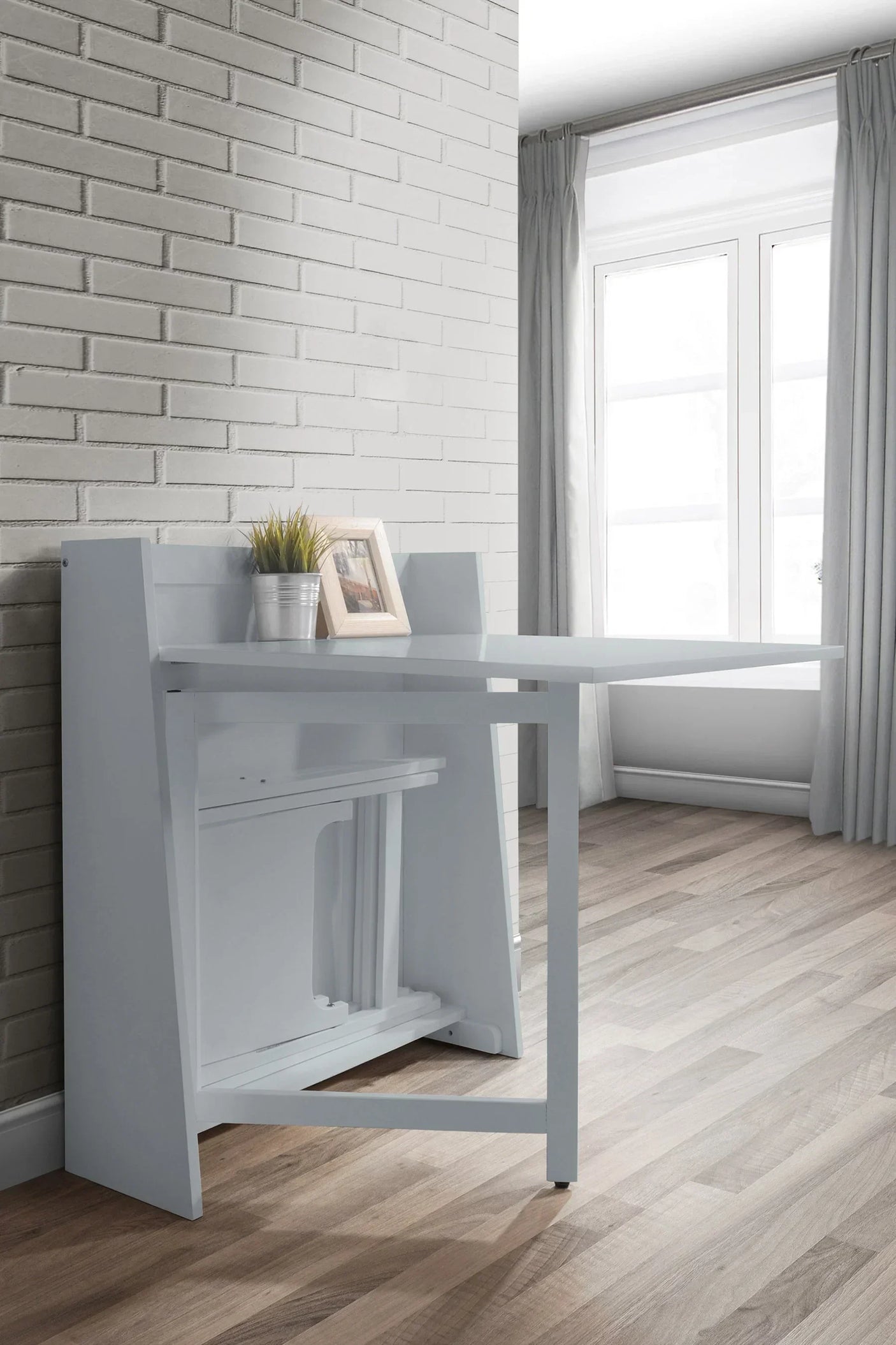 Light grey compact folding dining set against a white brick wall in a bright room