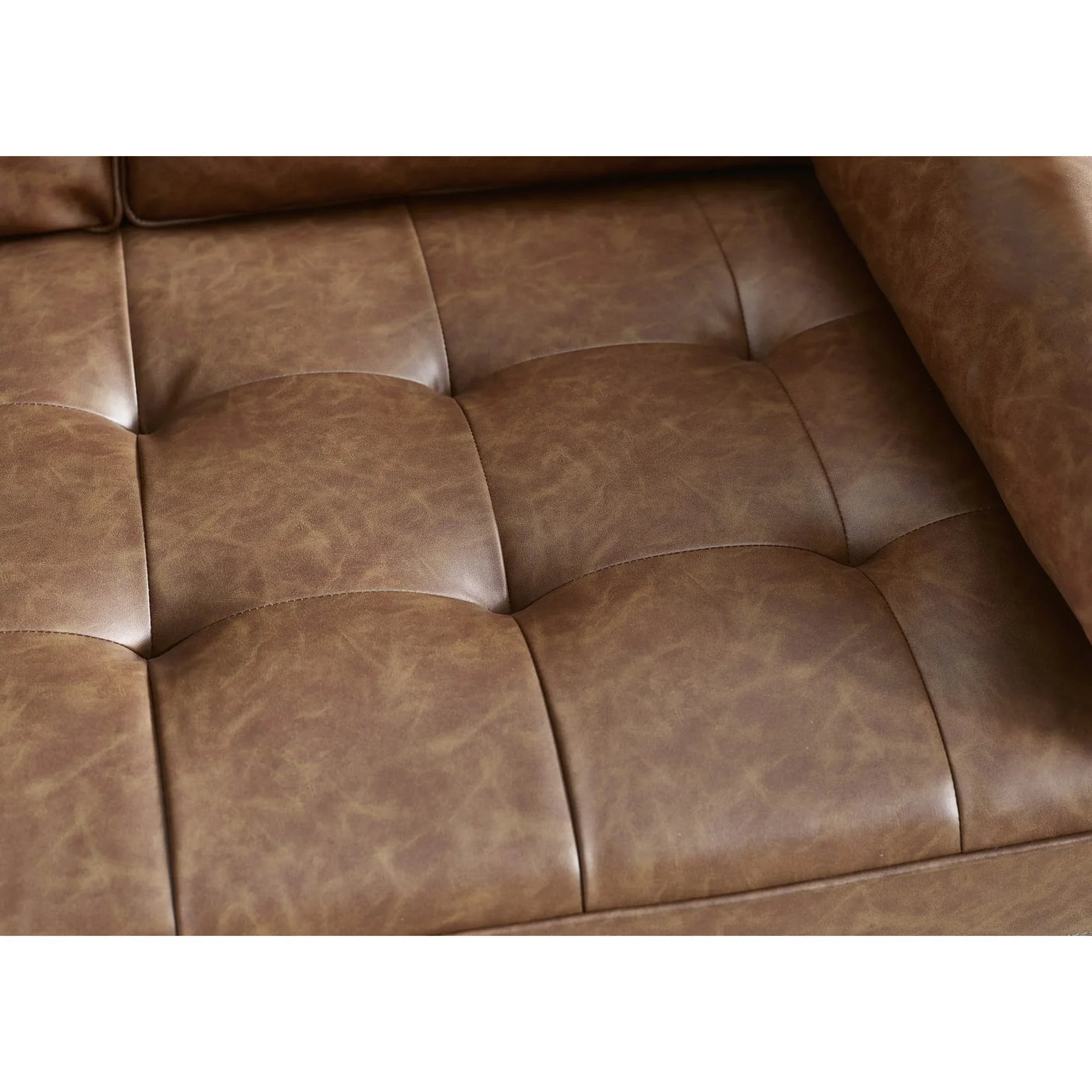 Closeup of brown leather sofa seat cushion with tufted stitching detail