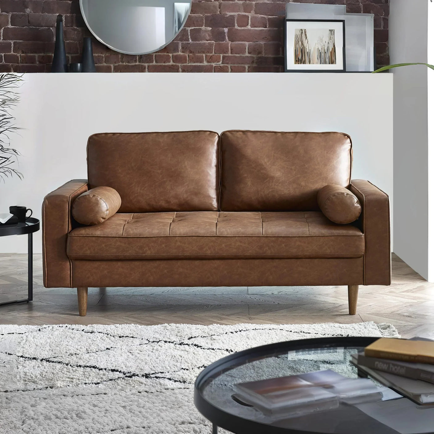 Brown leather sofa with bolster cushions in modern living room setting