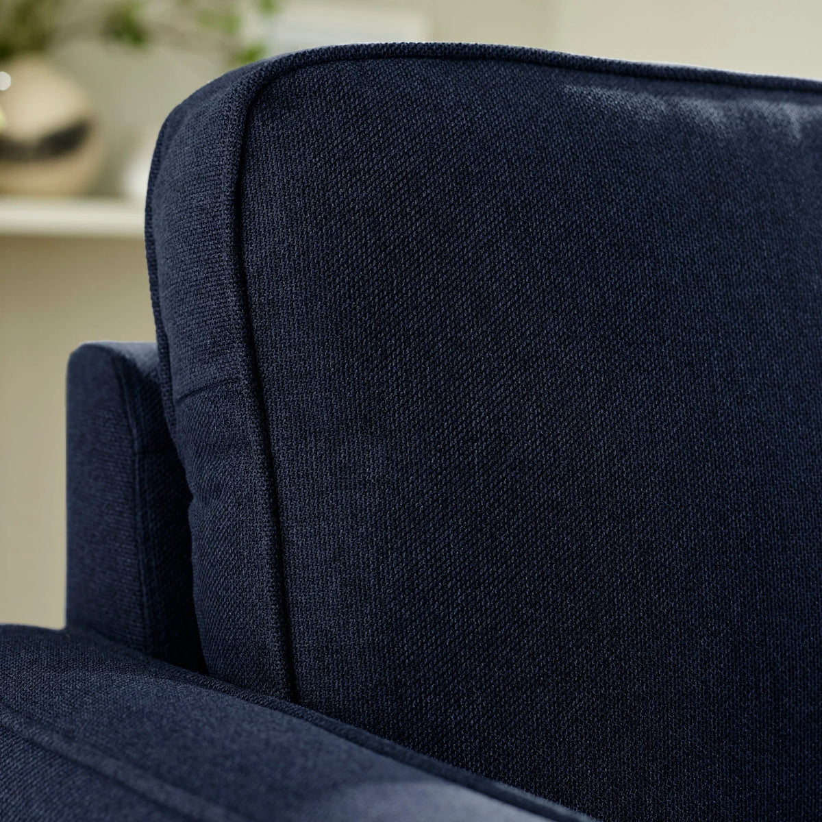Closeup of navy fabric sofa backrest and armrest texture